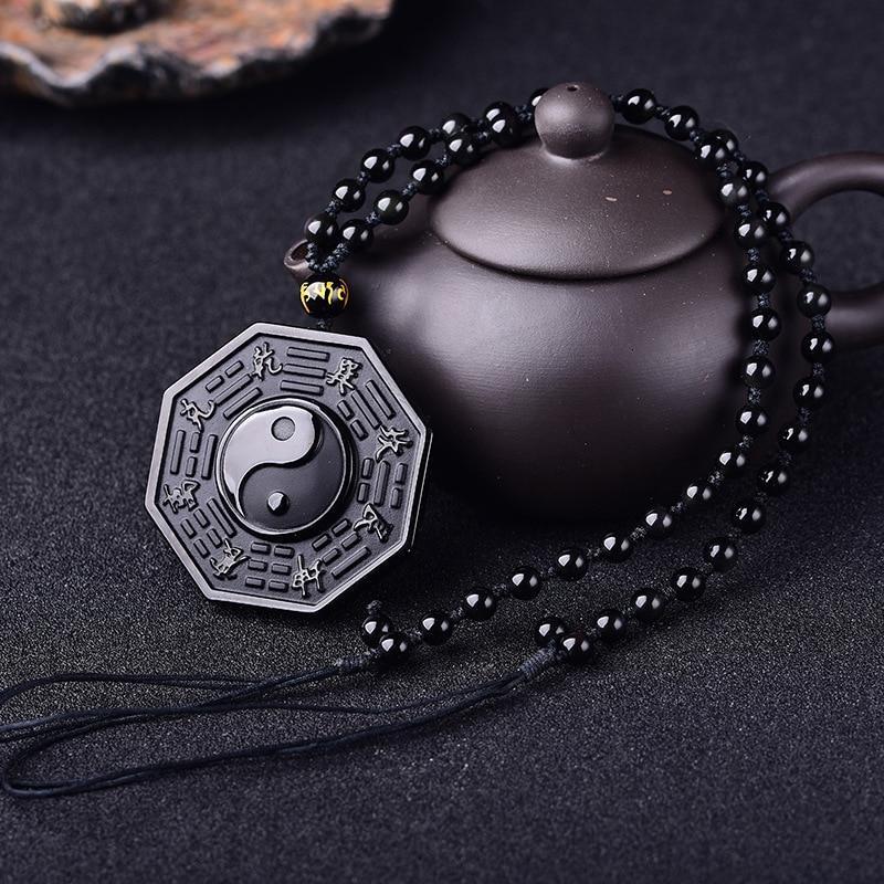 Colar Obsidiana Yin Yang Sob Superfície Escura.