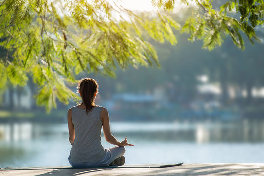 Mulher meditando em um ambiente tranquilo ao ar livre