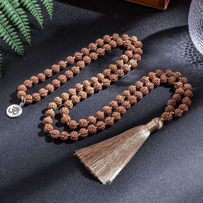 Japamala 108 Contas Rudraksha sobre fundo escuro com iluminação suave.