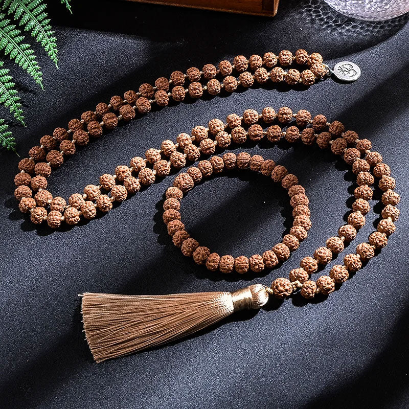 Japamala 108 Contas Rudraksha sobre fundo escuro iluminado.