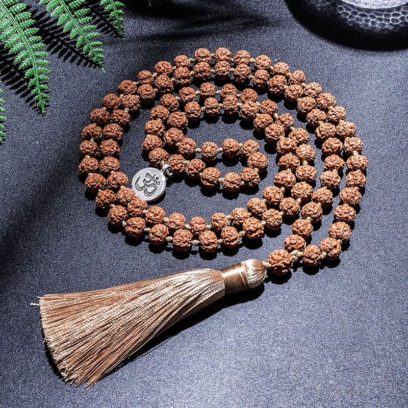 Japamala 108 Contas Rudraksha sobre fundo escuro.