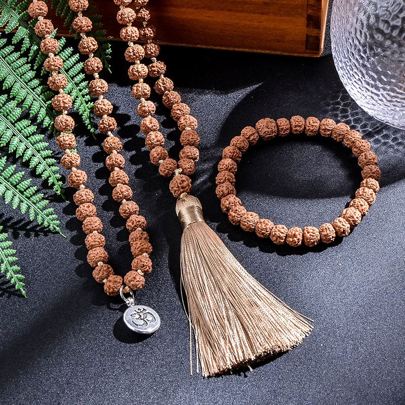 Japamala 108 Contas Rudraksha sobre superfície escura iluminada.