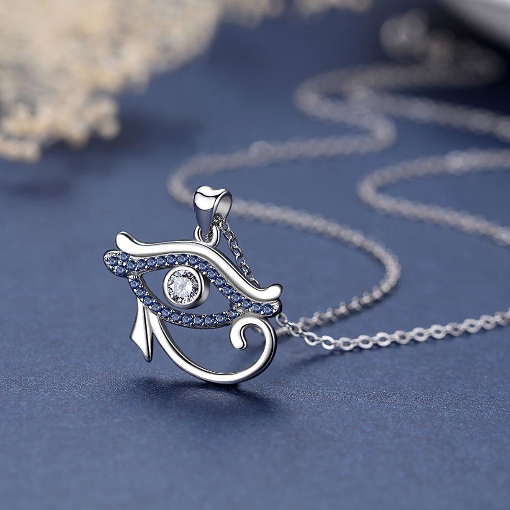 Colar Feminino Olho de Hórus em prata 925 com pedras azuis cravejadas e cristal no centro, exibido sobre fundo azul com corrente delicada.